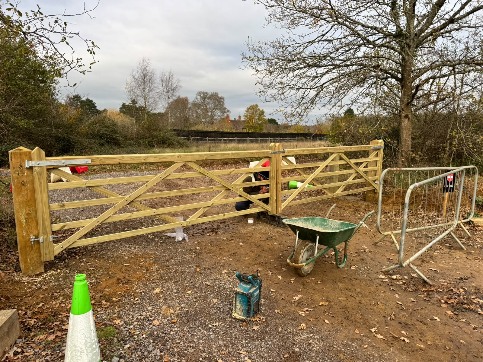 Five-bar gates being hung on new posts in a countryside setting
