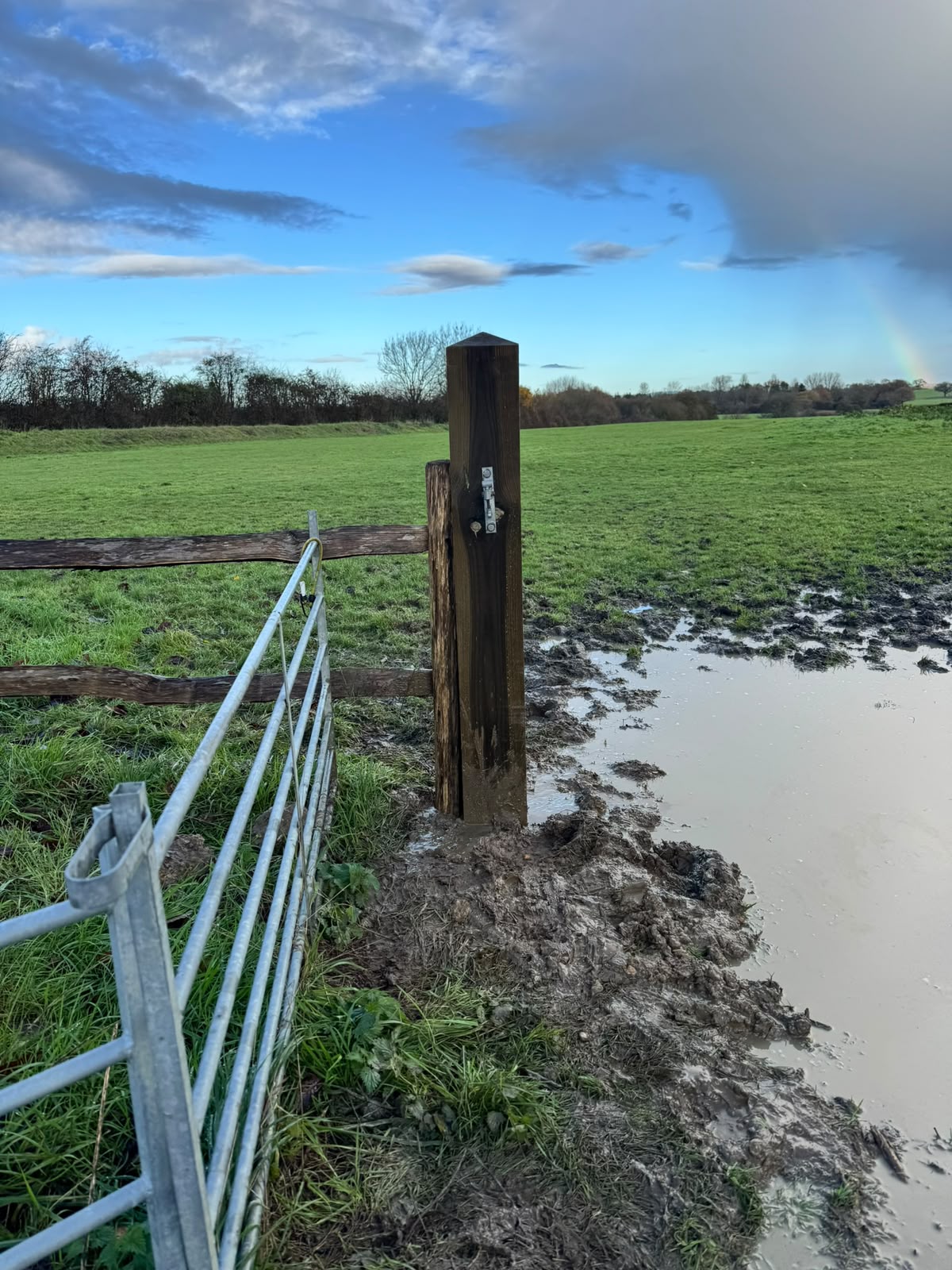 Solid gate post set beside open countryside