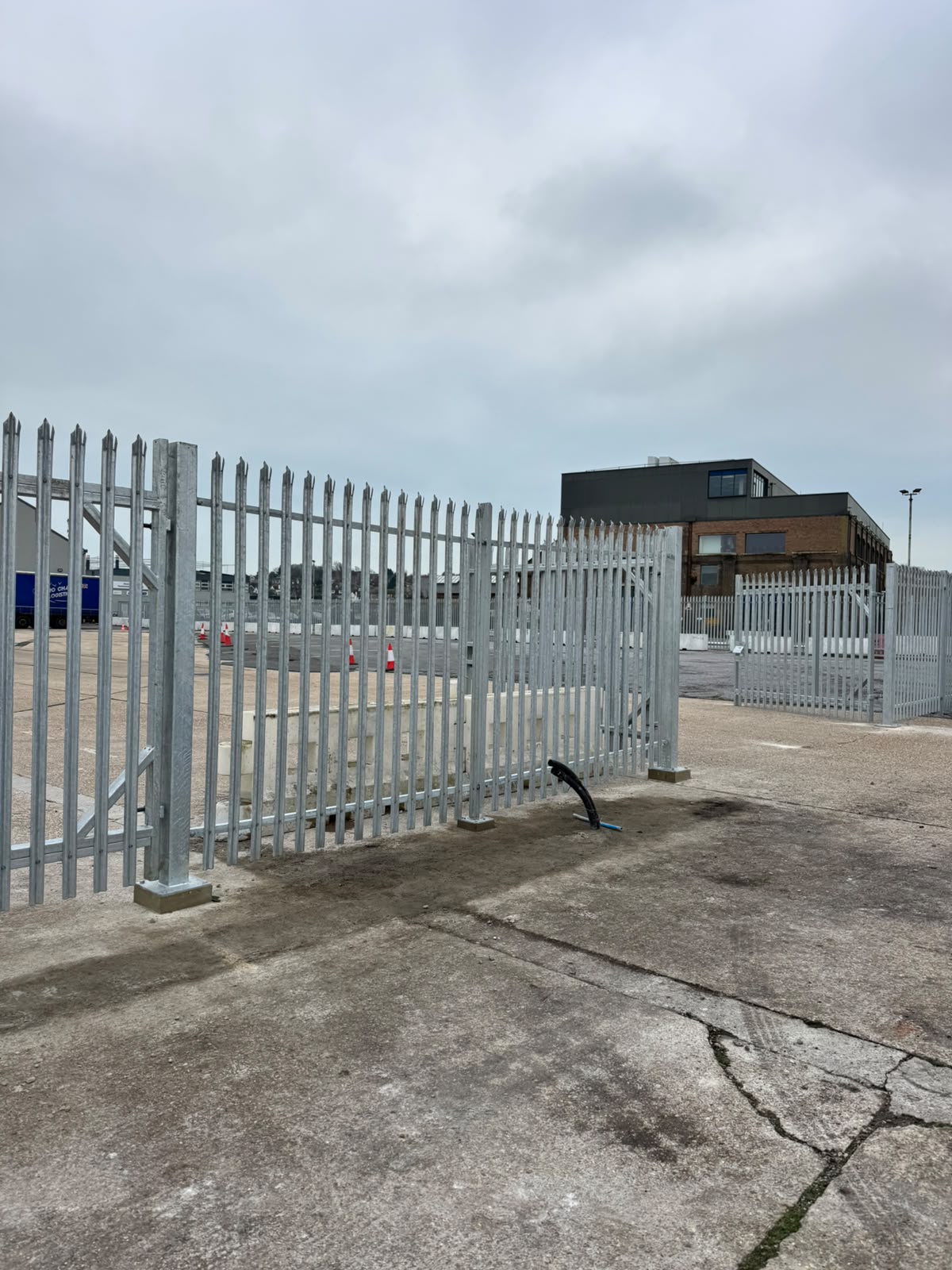 Galvanised palisade fencing enclosing a commercial yard