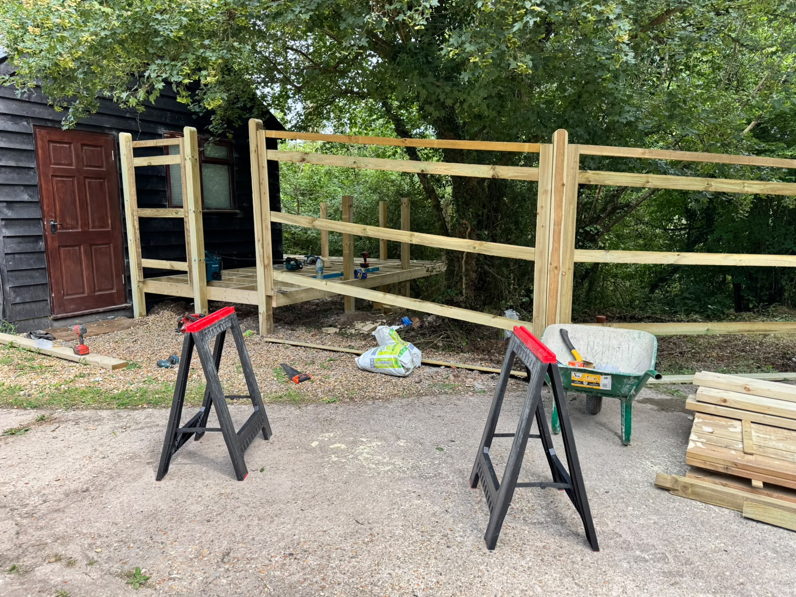 Timber deck frame being built beside a cabin with the rail structure in place