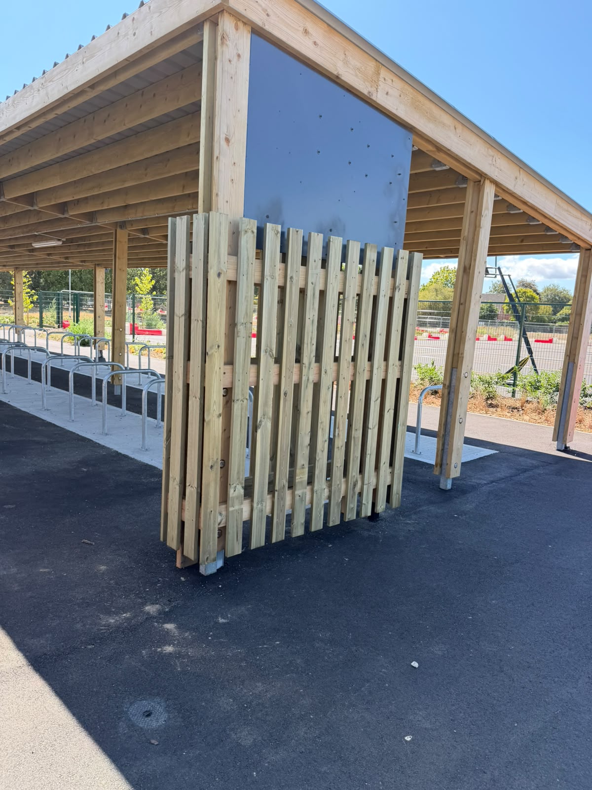 Vertical picket screens enclosing a covered cycle shelter