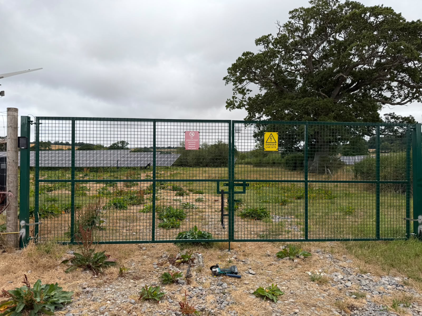 Green welded mesh double gates at a solar farm field entrance