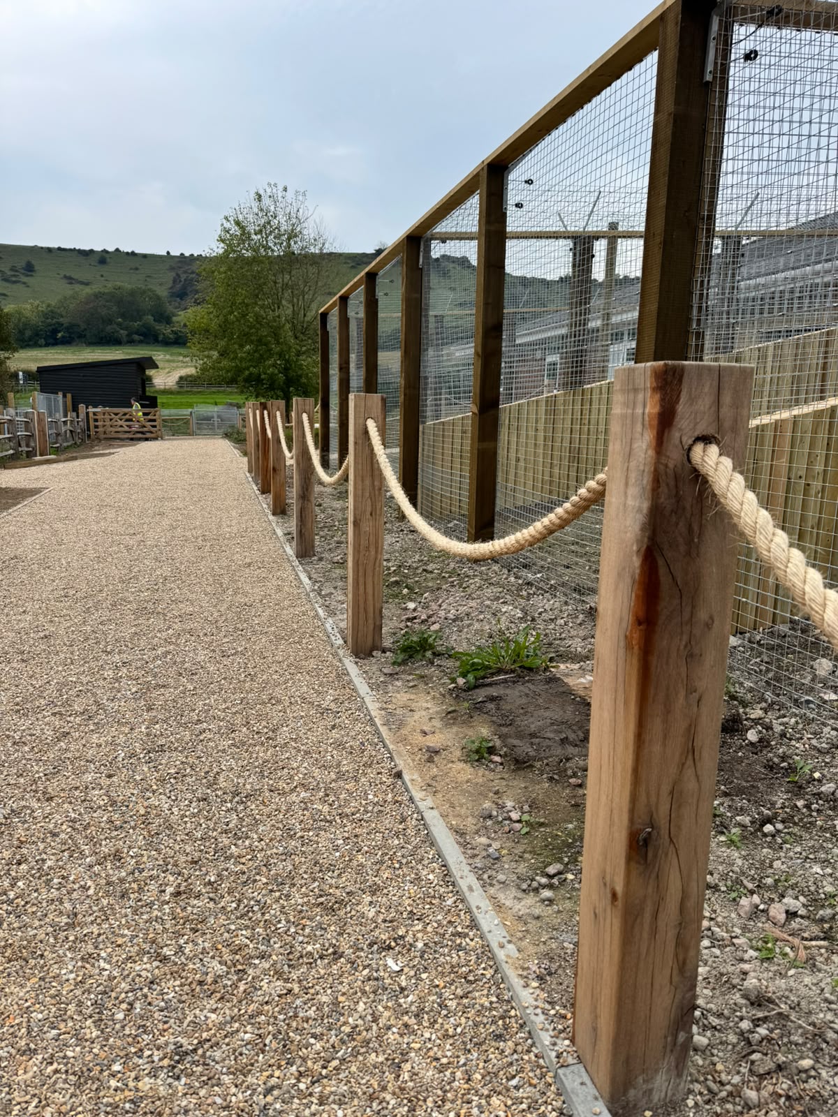 Timber posts with rope edging alongside a mesh run