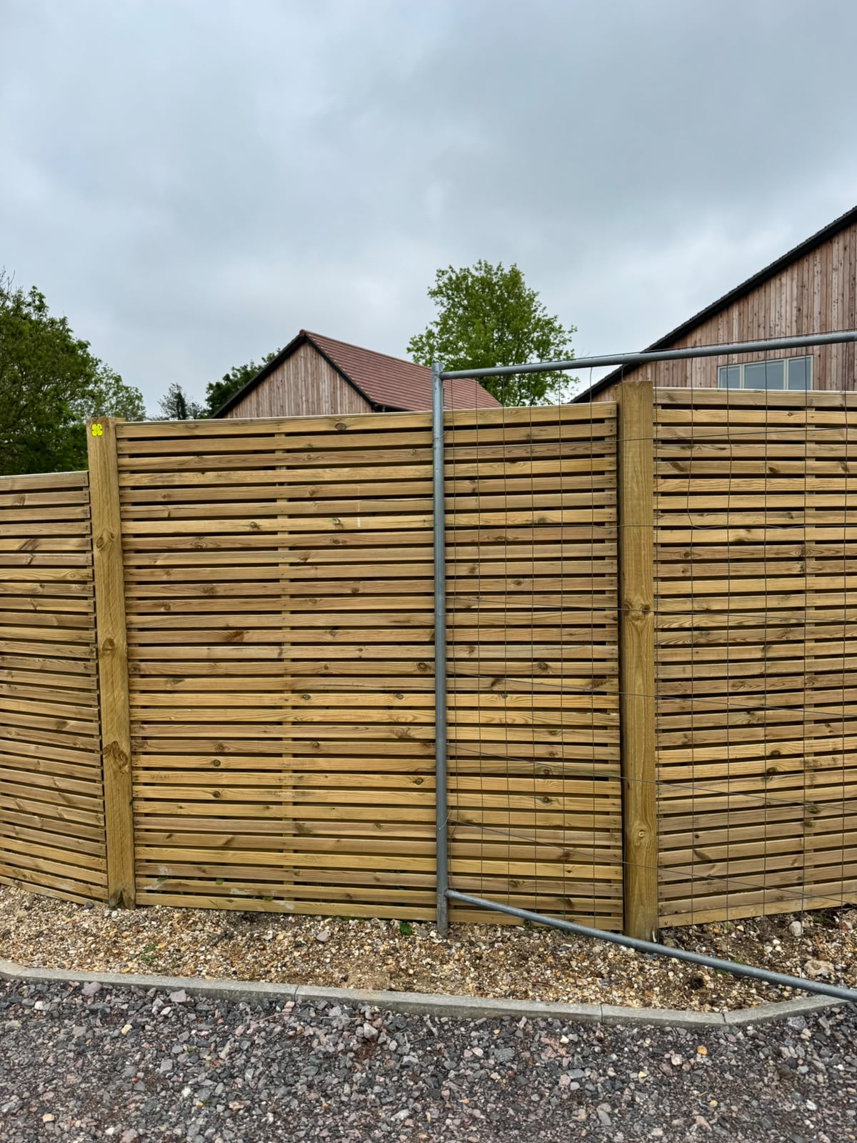 Modern horizontal slatted timber fencing following a curved boundary