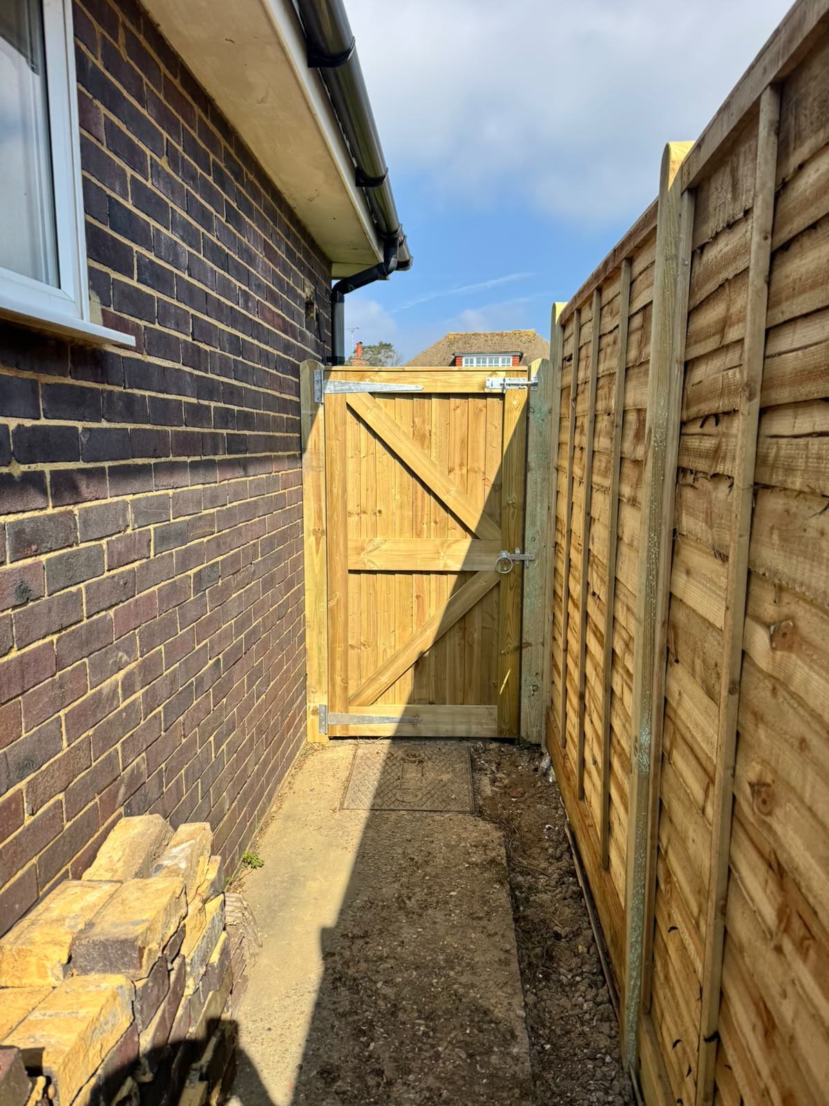 Closeboard run with a framed and braced side gate between a house and garden