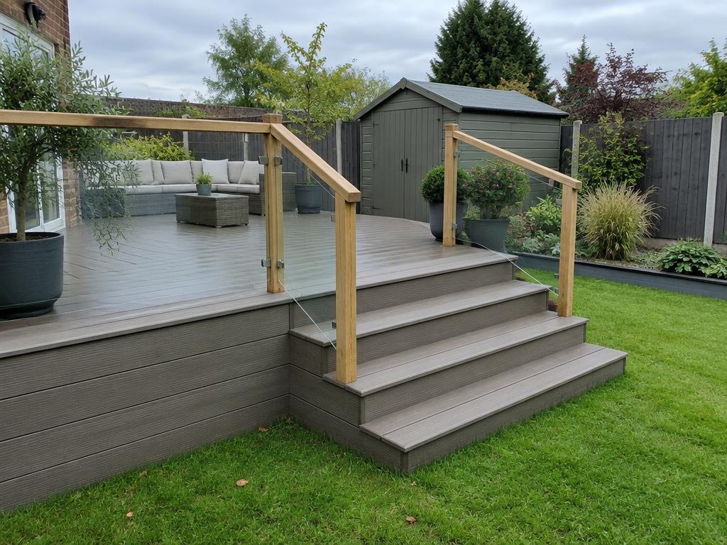 Raised composite decking platform with steps down to a lawn